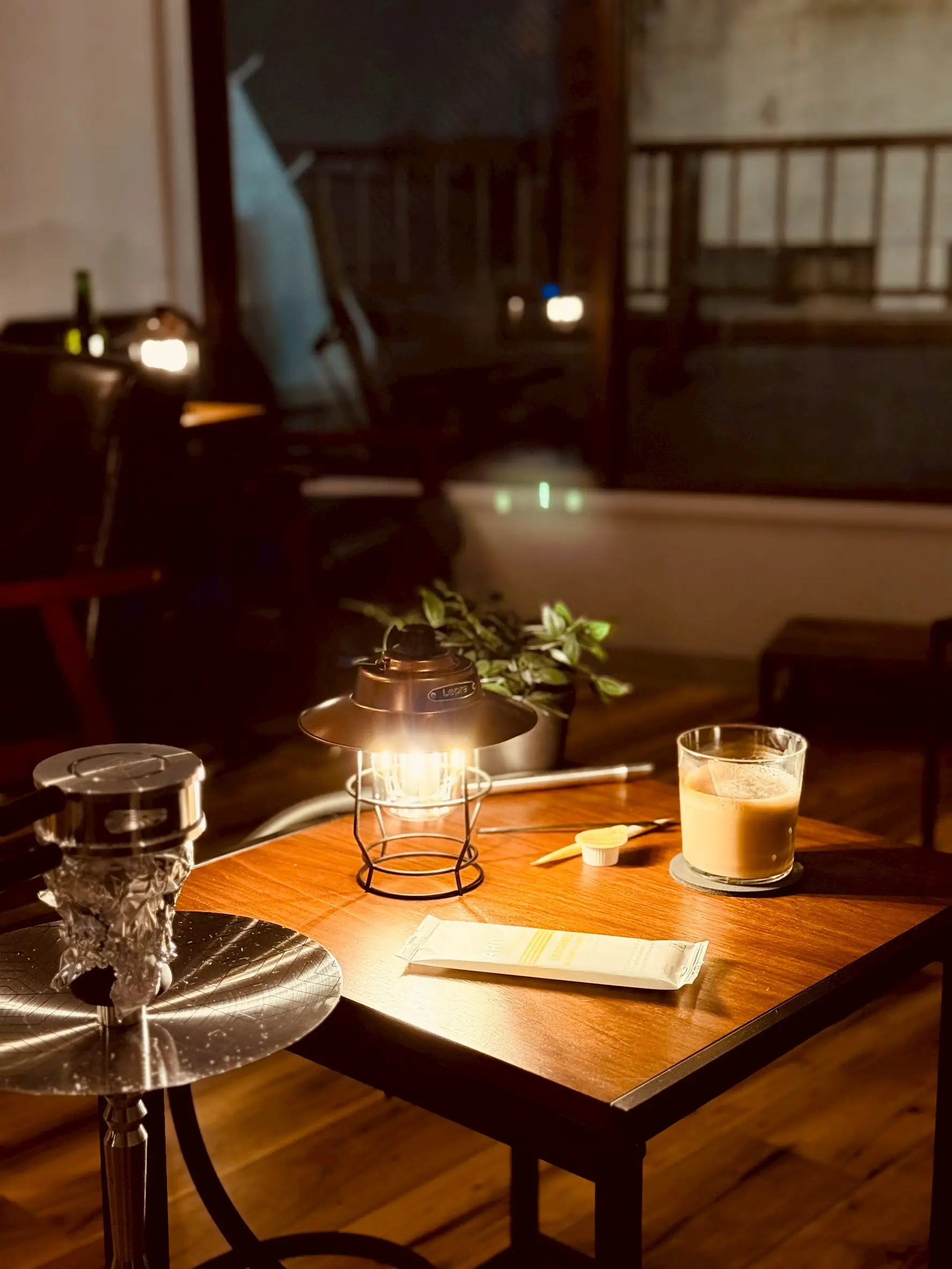 夜の shisha bar IORI。ランプの灯るテーブル席とシーシャ、ドリンク
